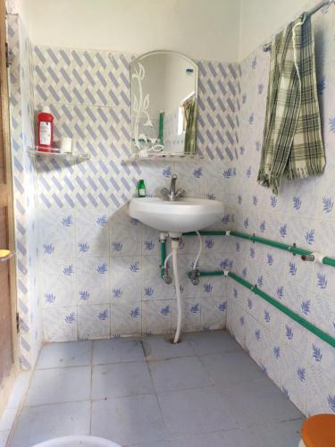 a bathroom with a sink and a mirror at Nawang HomeStay in Kaza