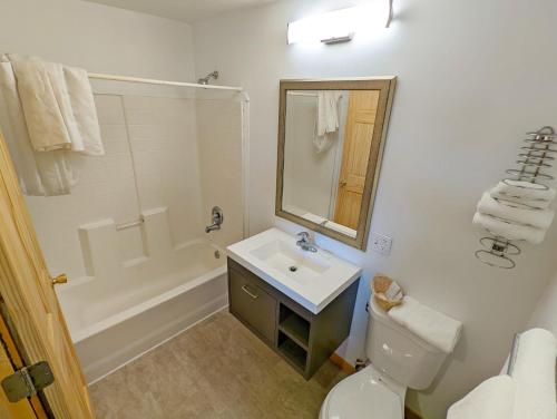 a bathroom with a sink and a toilet and a tub at Teton Court Motel in Pinedale