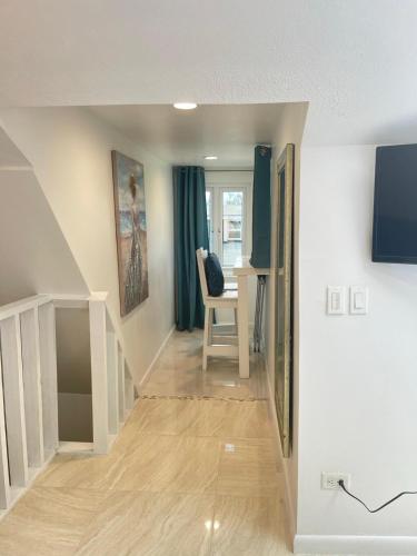 a hallway with a staircase with a chair and a desk at #6 Ferguson Rd - Townhouse in Nassau