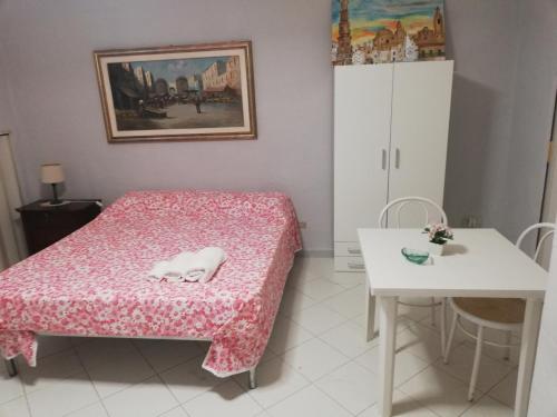 a small room with a bed and a table at La casetta di Mary in Monopoli