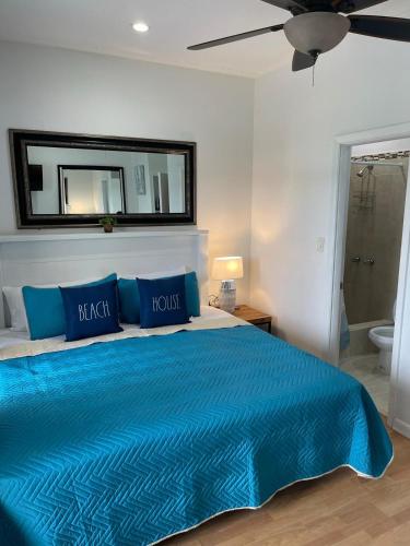 a bedroom with a bed with blue sheets and a mirror at #6 Ferguson Rd - Townhouse in Nassau