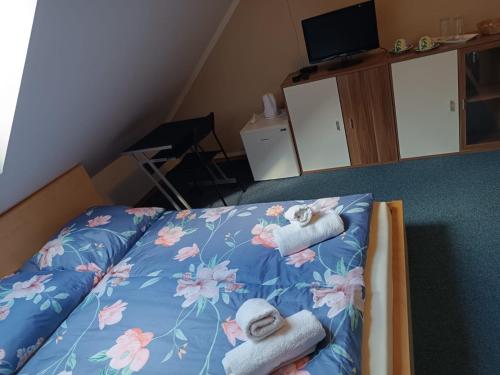 a bedroom with a bed with towels on it at Restaurace a Penzion U Lesa in Havířov