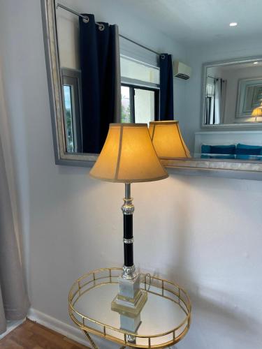 a lamp on a glass table in a room with mirrors at #6 Ferguson Rd - Townhouse in Nassau
