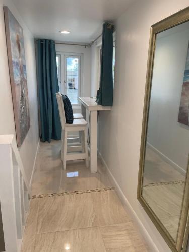 a hallway with a mirror and a table and a chair at #6 Ferguson Rd - Townhouse in Nassau