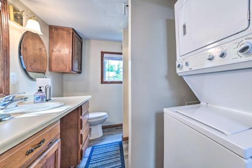a bathroom with a sink and a washer and dryer at East Tawas Lakefront Getaway with Kayaks and Deck in East Tawas