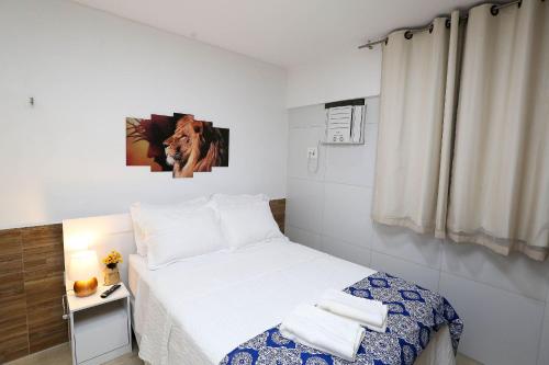 a small bedroom with a bed with white sheets at Studio Manaíra #805 - Flat na Praia por Carpediem in Tambaú
