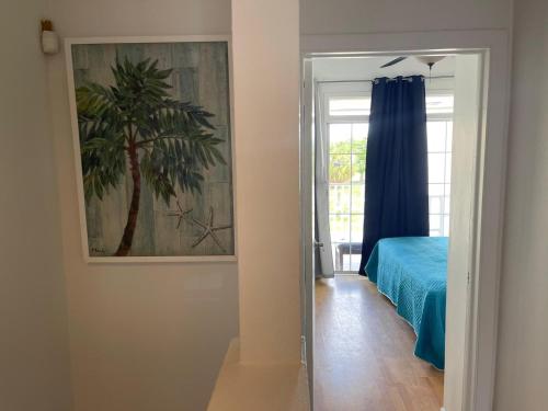 a bedroom with a painting of a palm tree on the wall at #6 Ferguson Rd - Townhouse in Nassau