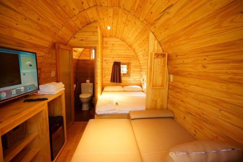 a small room with a bed in a wooden cabin at Long Hải Channel Beach Resort in Long Hai