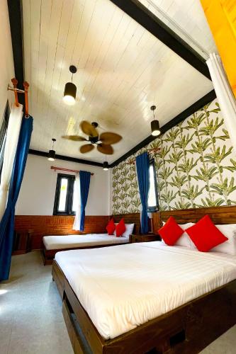 a bedroom with a bed with red pillows and a ceiling at Long Hải Channel Beach Resort in Long Hai