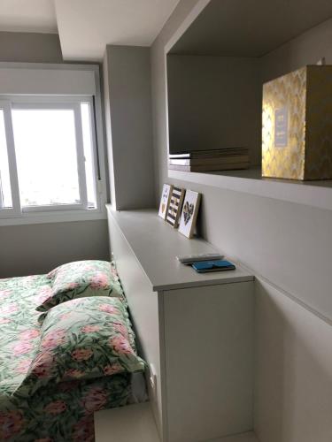 a small bedroom with a bed and a window at Loft 1303 Maxplaza, Encantador, piscina, garagem in Canoas
