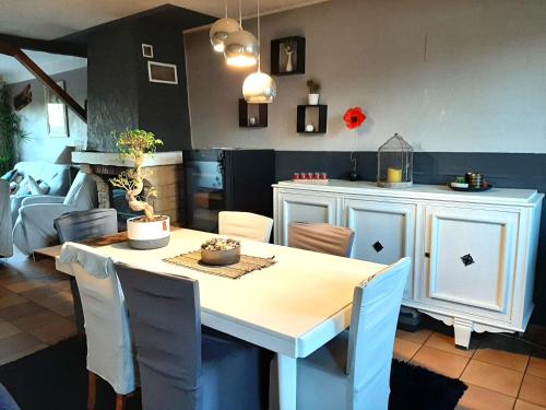 une cuisine avec une table avec des chaises et une salle à manger dans l'établissement LA GRAN'EXOTIQUE, à Nouvion-en-Ponthieu