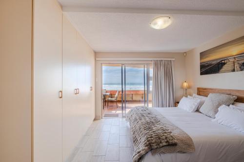 a bedroom with a bed and a view of the ocean at Jeffreys Bay Beach Accommodation in Jeffreys Bay