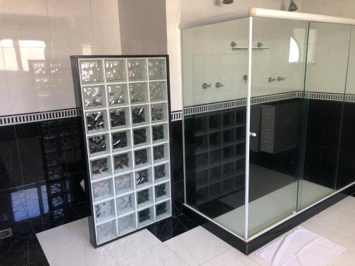 a glass shower stall with a glass door in a bathroom at Hotel Pousada Irmaos Freyhardt in Rio de Janeiro