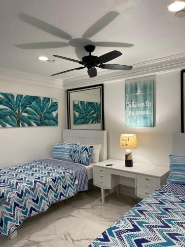 a bedroom with two beds and a ceiling fan at #6 Ferguson Rd - Townhouse in Nassau
