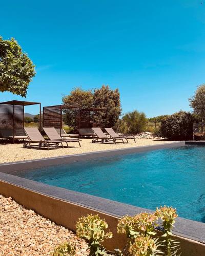 - une piscine avec des chaises longues et des chaises à côté dans l'établissement Le Vieux Portail, à Saint-Saturnin-lès-Apt