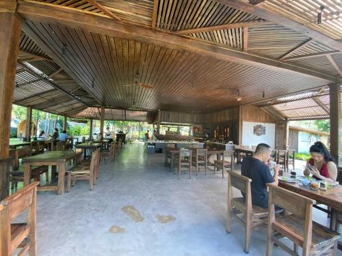 a group of people sitting at tables in a restaurant at Long Hải Channel Beach Resort in Long Hai