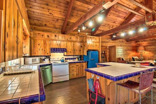 a large kitchen with wooden walls and wooden floors at 1 Mi to Rainbow Lake Lakeside Cabin with Deck! in Lake of the Woods