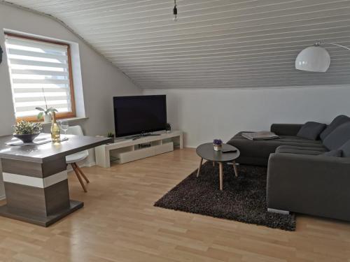 a living room with a couch and a tv at Ferienwohnung am Kirchfeld in Rotthalmünster