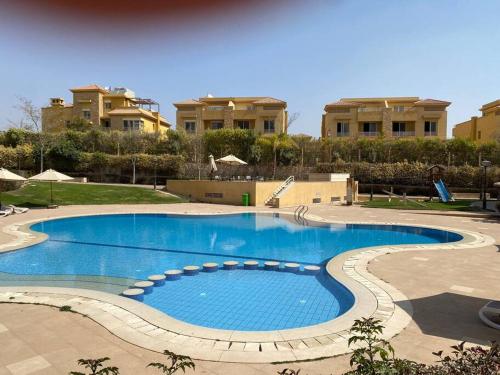 a large swimming pool in front of some buildings at Lovely 3-Bedroom Rental Unit with Pool in Sheikh Zayed