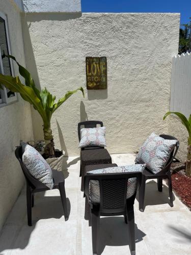a patio with chairs and a table and a sign that reads love shop at #6 Ferguson Rd - Townhouse in Nassau