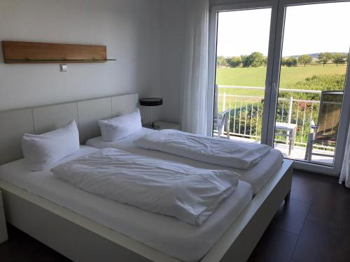 Un dormitorio con dos camas y una gran ventana. en Serviced Apartments Hertingen, en Bad Bellingen
