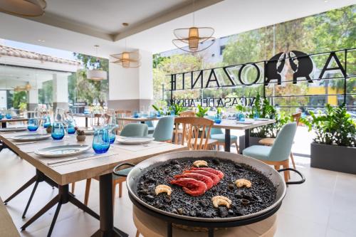 a barbecue in a restaurant with tables and chairs at Occidental Puerto Banús in Marbella