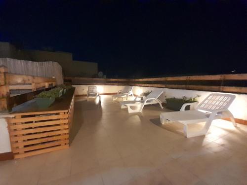 a patio with lounge chairs and lights at night at Case Vacanze "Residenze Trapanesi" in Trapani