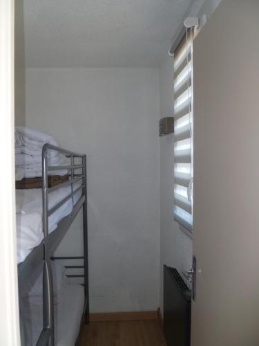 1 dormitorio con litera y ventana en Risoul 1850 appartement 4 personnes proches pistes. en Risoul