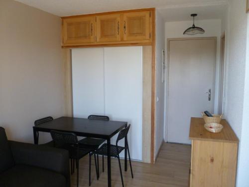 a living room with a table and chairs and a door at Risoul 1850 appartement 4 personnes proches pistes. in Risoul