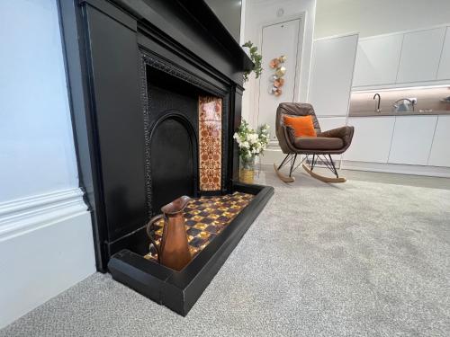 a black fireplace with a vase sitting inside of it at Winckley Square Residences in Preston