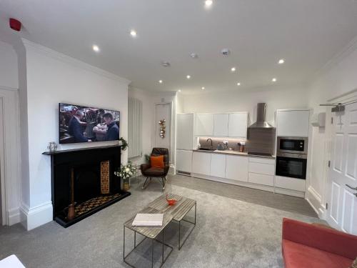 a living room with a fireplace and a kitchen at Winckley Square Residences in Preston