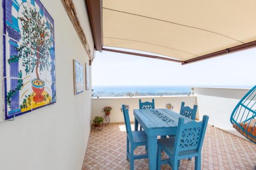 una mesa azul y sillas en el balcón en BnB Sant'Alfonso en Agrigento