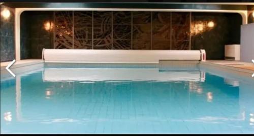 a large swimming pool with blue water at Apartment in München in Munich