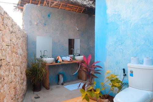 a bathroom with two sinks and a blue wall at Kusini beach bungalows in Kizimkazi
