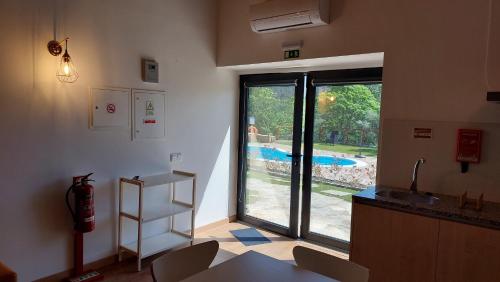 a room with a kitchen with a view of a pool at Green Paradise Glamping in Covas