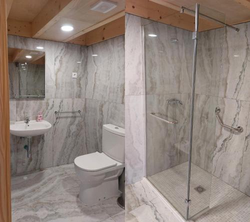 a bathroom with a toilet and a shower and a sink at Green Paradise Glamping in Covas
