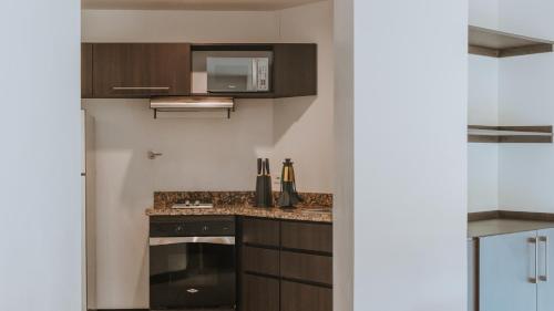 a kitchen with a stove and a microwave at Travelers Rio Verde Living Suites in Rionegro