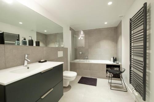a bathroom with a sink and a toilet and a tub at Superb 1 bedroom apartment with garden at châtelain in Brussels