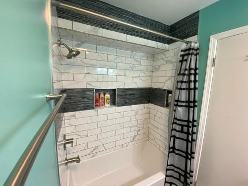 La salle de bains est pourvue d'une baignoire blanche et d'une douche. dans l'établissement The Great Escape With Friends & Family & Pets!!!, à Jacksonville
