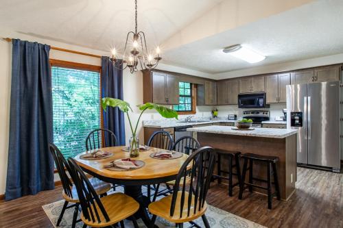 une cuisine et une salle à manger avec une table et des chaises dans l'établissement Highland Forest Cabins Duo Cabin Retreat, à Pigeon Forge