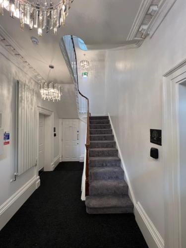 a staircase in a building with a chandelier at Winckley Square Residences in Preston