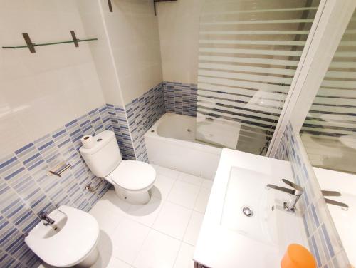 een badkamer met een toilet, een wastafel en een bad bij Mexico II in Cambrils