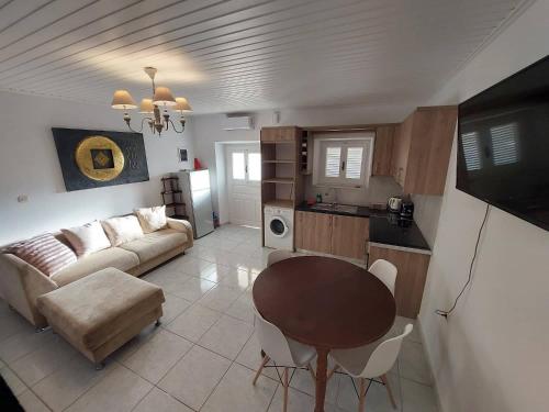 een woonkamer met een bank en een tafel bij Alegria House 150m from the beach in Gouvia