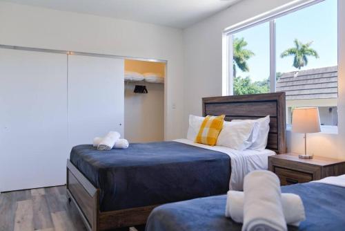 1 dormitorio con 2 camas y ventana grande en Awesome Townhouse 15 minutes from the Beach en Miami