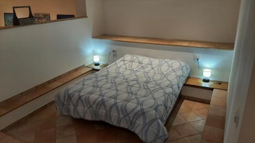 a small bedroom with a bed and two night stands at Il Corbezzolo in Paciano