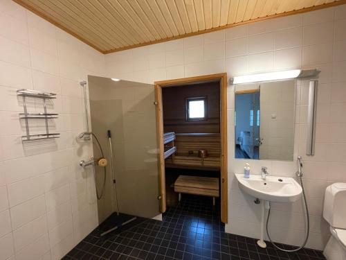 La salle de bains est pourvue d'un lavabo et d'une douche. dans l'établissement Pan Golf & Spa Villas, à Imatra