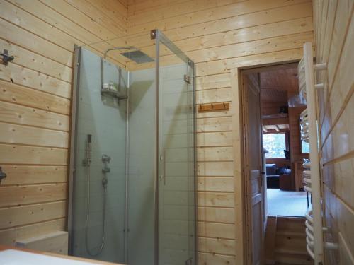 a bathroom with a shower in a wooden wall at Joli Chalet*** pied des pistes à Pyrénées 2000 in Bolquere Pyrenees 2000