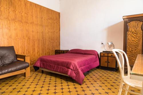 1 dormitorio con 1 cama, 1 silla y 1 mesa en Alojamiento Aloja N1 en Mendoza
