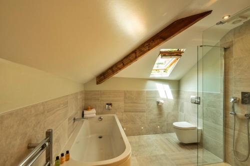 a bathroom with a tub and a toilet and a shower at Finest Retreats - The Old Post Office Apartment 3 in Buxton