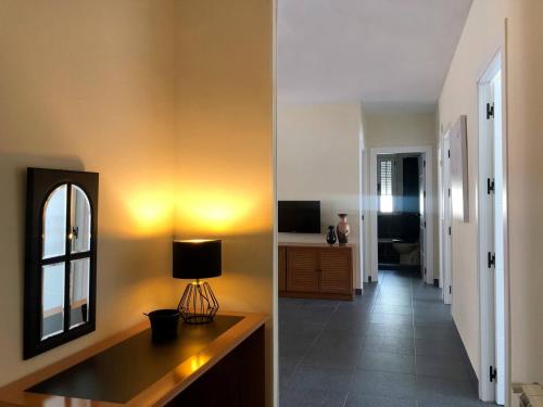 Habitación con pasillo con espejo y lámpara. en La Duquesa del Valle, en Cabezuela del Valle